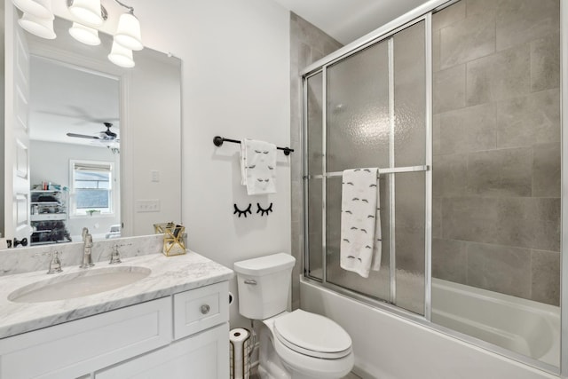 full bath featuring shower / bath combination with glass door, vanity, toilet, and ceiling fan