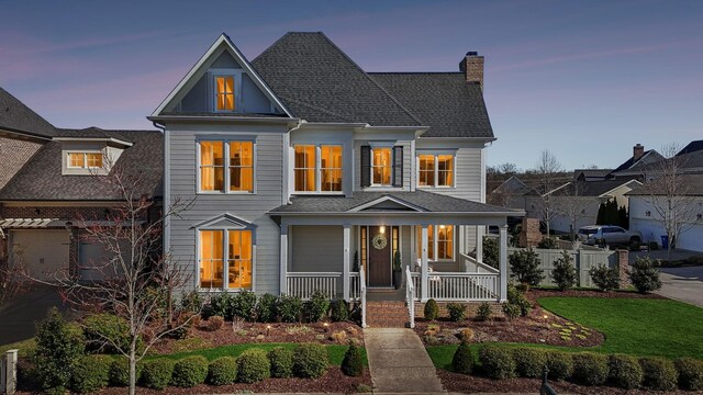 view of front of property featuring a chimney and covered porch