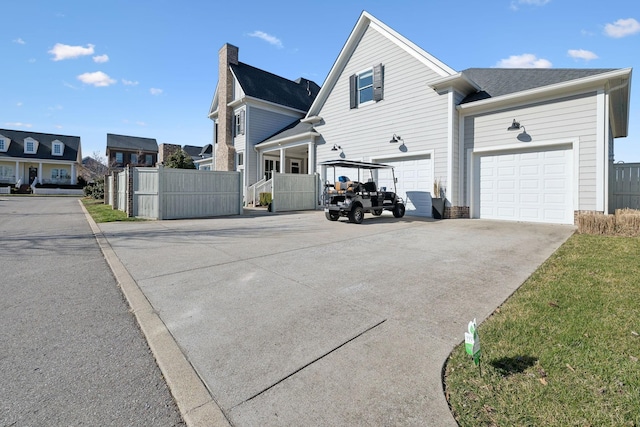 view of property exterior featuring fence, driveway, and a chimney