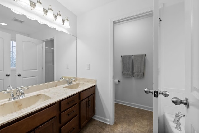 bathroom featuring a sink, visible vents, baseboards, and double vanity