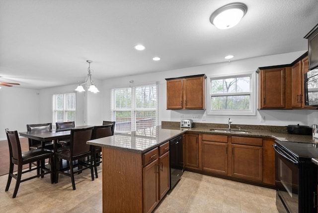 kitchen with a sink, recessed lighting, a peninsula, dark stone counters, and black appliances