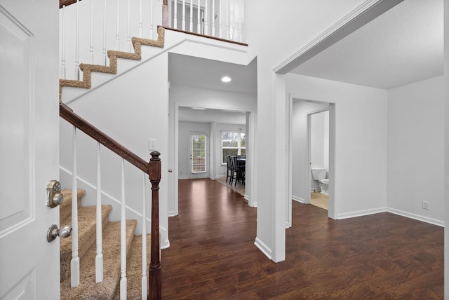 entrance foyer featuring recessed lighting, stairway, a high ceiling, wood finished floors, and baseboards