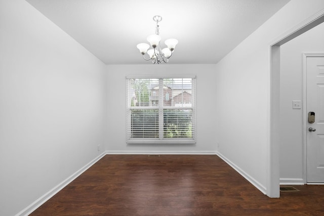 unfurnished dining area with baseboards, an inviting chandelier, and wood finished floors