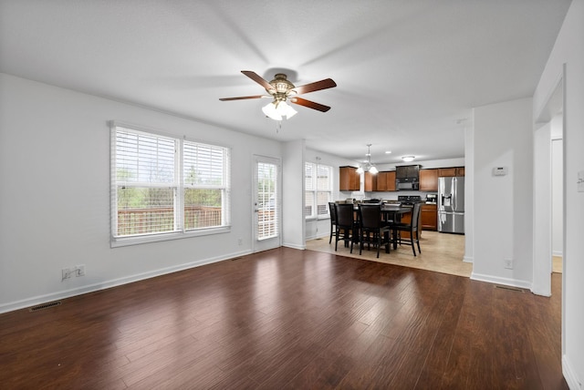 unfurnished living room featuring wood finished floors, ceiling fan, baseboards, and visible vents