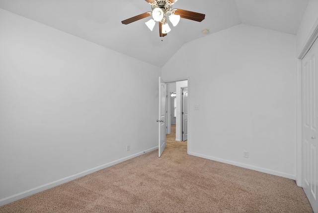 unfurnished bedroom featuring a closet, baseboards, a ceiling fan, vaulted ceiling, and light carpet