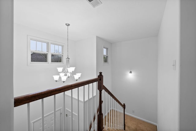 staircase with baseboards, visible vents, a notable chandelier, and carpet