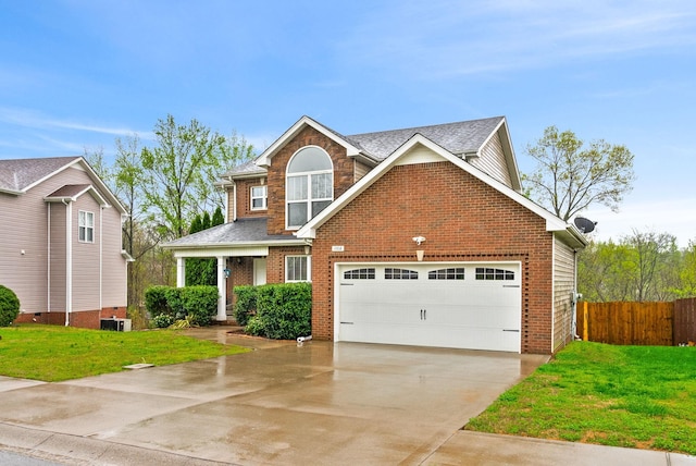 traditional-style home with a front yard, fence, brick siding, an attached garage, and driveway
