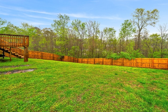 view of yard with stairs, a fenced backyard, and a wooden deck