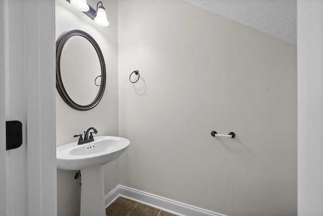 bathroom featuring tile patterned floors, baseboards, and a textured ceiling