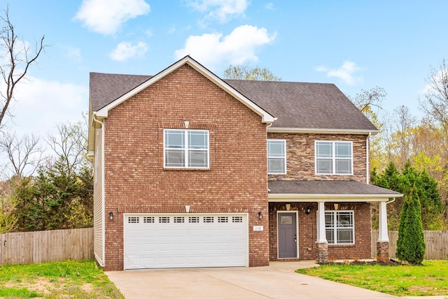 traditional home featuring an attached garage, fence, driveway, and roof with shingles