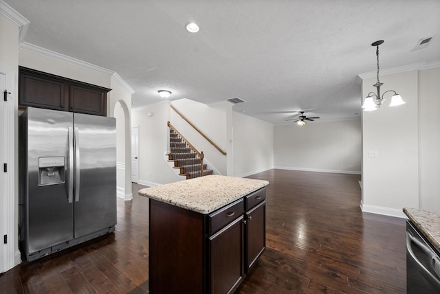 kitchen with appliances with stainless steel finishes, arched walkways, dark wood-style floors, and ceiling fan with notable chandelier