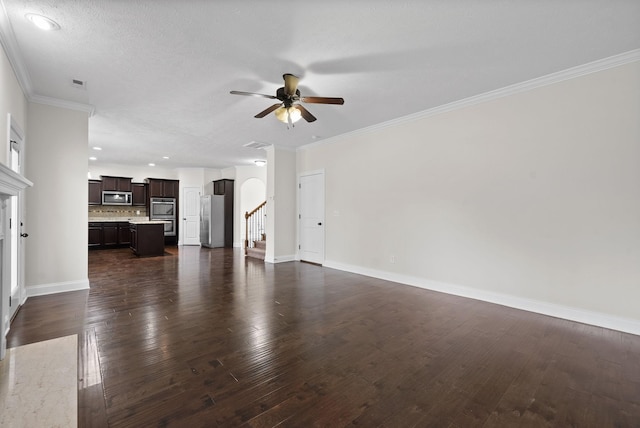 unfurnished living room featuring baseboards, crown molding, dark wood-type flooring, visible vents, and ceiling fan