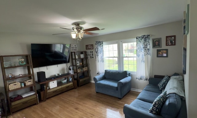 living room featuring baseboards, a ceiling fan, and wood finished floors