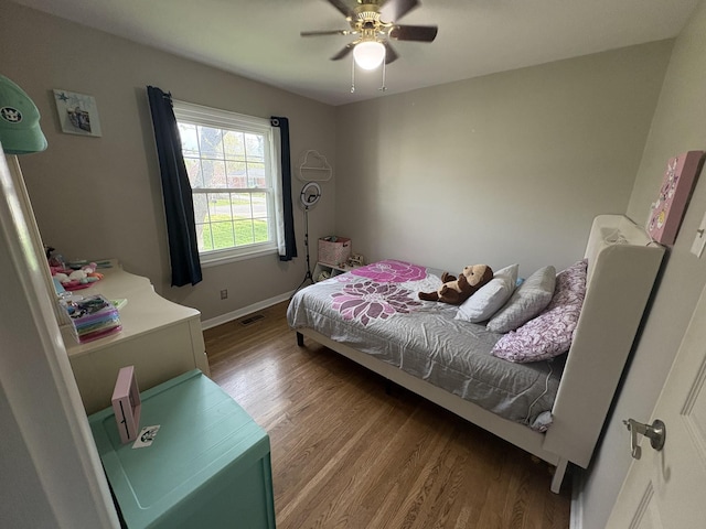 bedroom featuring wood finished floors, ceiling fan, baseboards, and visible vents