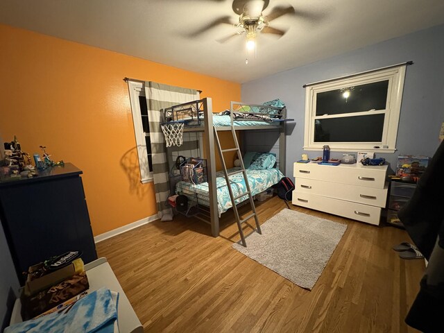 bedroom featuring wood finished floors, ceiling fan, and baseboards