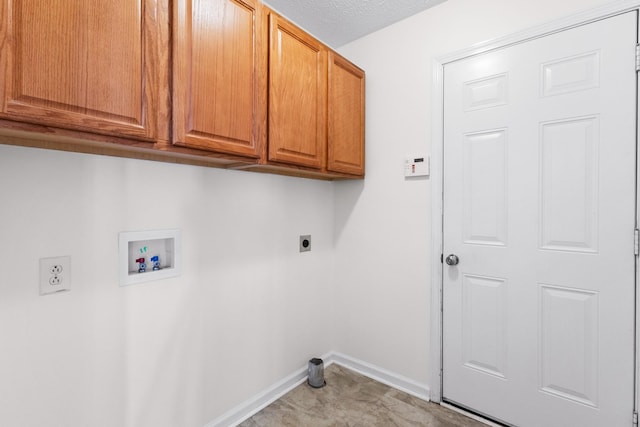 clothes washing area featuring baseboards, a textured ceiling, hookup for an electric dryer, cabinet space, and hookup for a washing machine