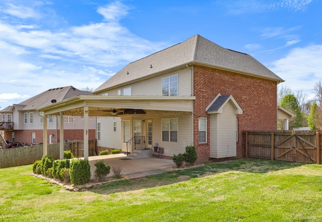 back of property featuring entry steps, a lawn, a fenced backyard, a patio, and brick siding