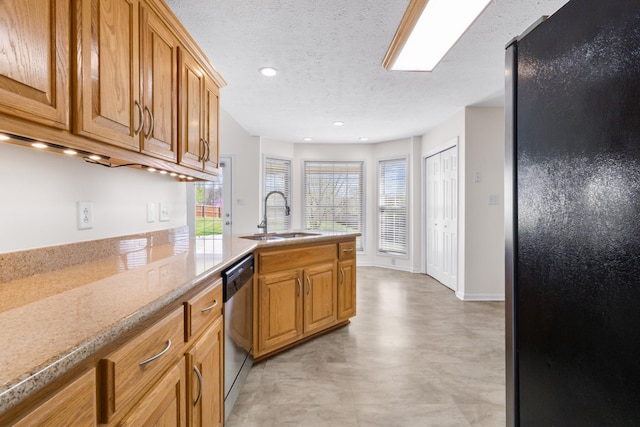 kitchen with a peninsula, a textured ceiling, freestanding refrigerator, stainless steel dishwasher, and a sink