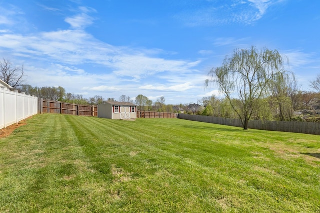 view of yard with a fenced backyard, an outbuilding, and a storage unit