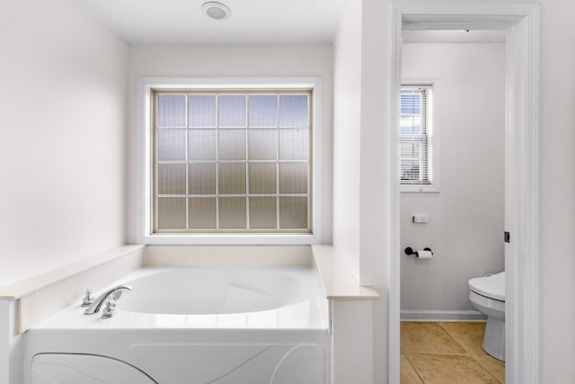 bathroom with toilet, tile patterned flooring, and a garden tub