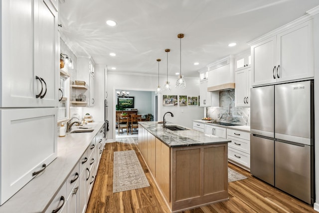 1132 Roseland Dr, Columbia, TN 38401 - kitchen featuring freestanding refrigerator, a kitchen island with sink, wood finished floors, and a sink
