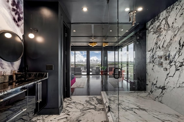 hallway with stone wall, marble finish floor, and recessed lighting