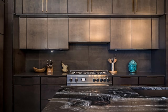kitchen with high end stainless steel range, decorative backsplash, dark brown cabinetry, and dark countertops
