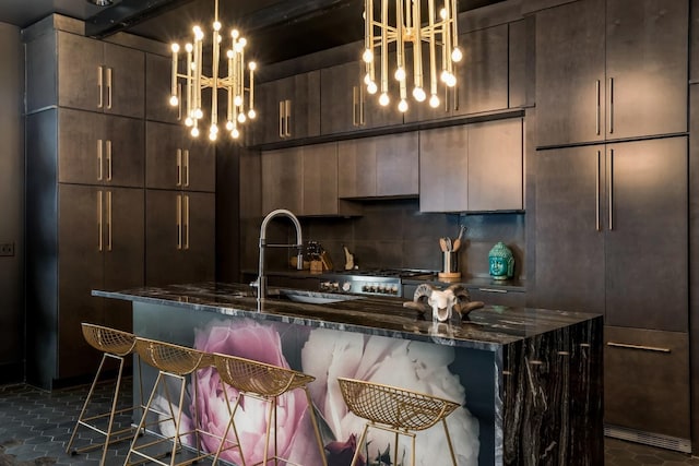 kitchen featuring dark stone counters, a breakfast bar area, an inviting chandelier, dark brown cabinetry, and range