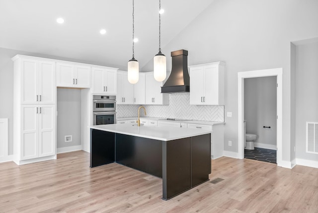 307 Riverview Dr, Dover, TN 37058 - kitchen featuring premium range hood, double oven, white cabinetry, tasteful backsplash, and light countertops