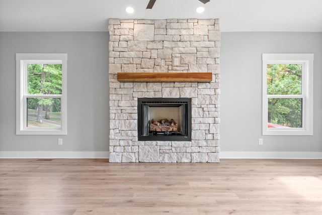 307 Riverview Dr, Dover, TN 37058 - detailed view of wood finished floors, a stone fireplace, baseboards, and a ceiling fan