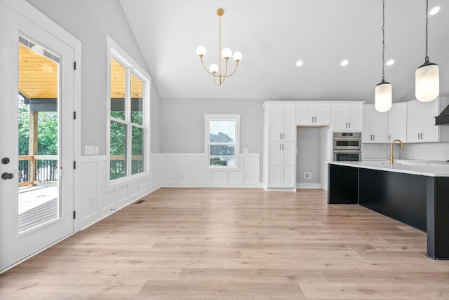 307 Riverview Dr, Dover, TN 37058 - kitchen with lofted ceiling, a chandelier, light countertops, stainless steel double oven, and plenty of natural light