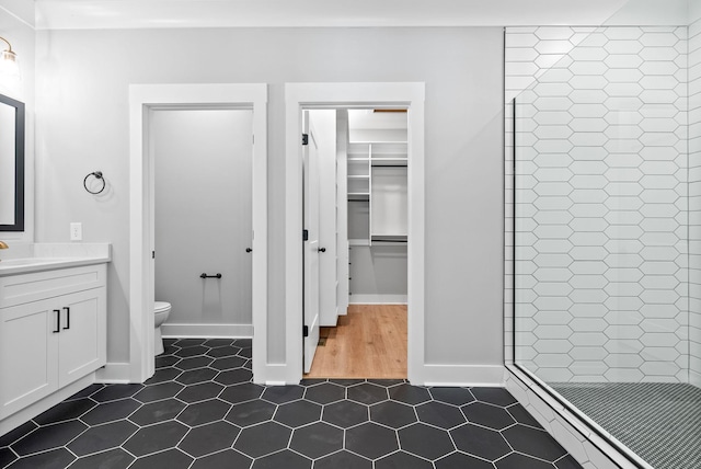 307 Riverview Dr, Dover, TN 37058 - bathroom featuring toilet, a stall shower, vanity, baseboards, and a walk in closet