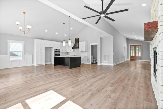 307 Riverview Dr, Dover, TN 37058 - unfurnished living room with a fireplace, ceiling fan, high vaulted ceiling, a chandelier, and light wood-type flooring