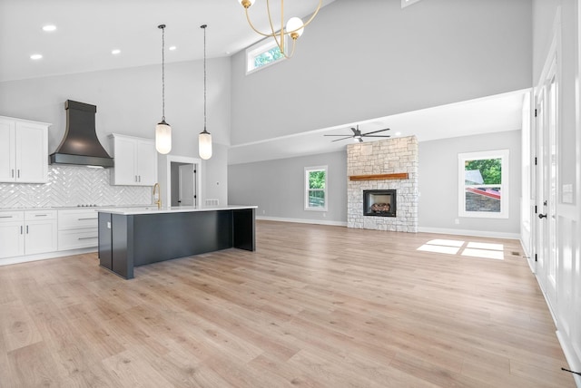 307 Riverview Dr, Dover, TN 37058 - kitchen featuring custom exhaust hood, a towering ceiling, a kitchen island with sink, white cabinets, and a ceiling fan