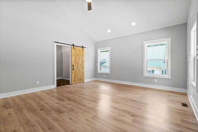 307 Riverview Dr, Dover, TN 37058 - unfurnished bedroom featuring a barn door, high vaulted ceiling, light wood finished floors, baseboards, and ceiling fan