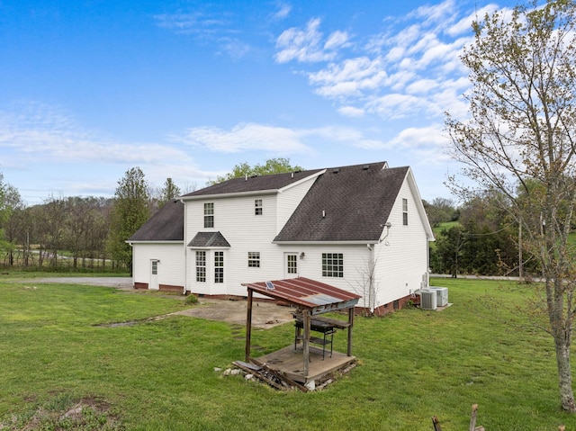 back of house featuring a yard, a patio area, cooling unit, and roof with shingles