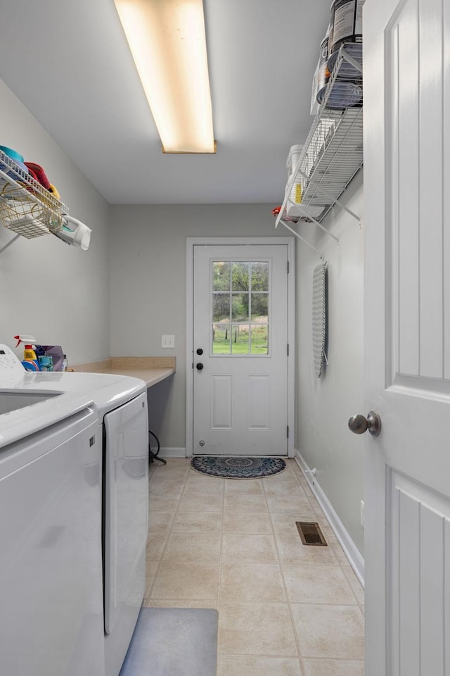 laundry area with visible vents, light tile patterned floors, baseboards, laundry area, and washing machine and dryer