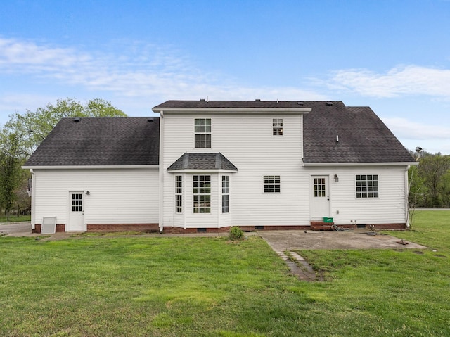 back of property featuring crawl space, roof with shingles, and a lawn