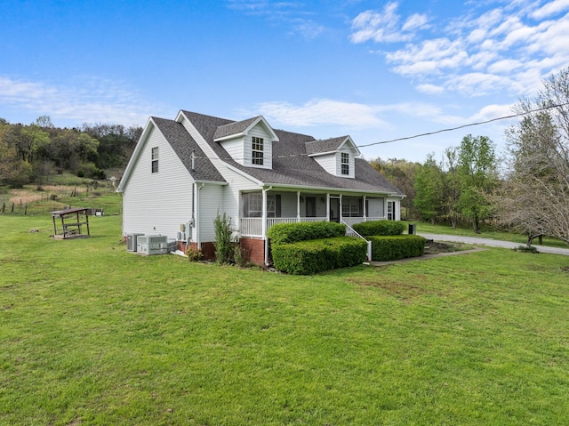 view of front facade featuring central AC, a front lawn, and roof with shingles