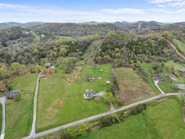 birds eye view of property with a wooded view and a mountain view