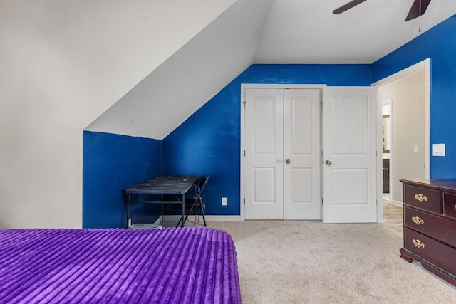 bedroom with baseboards, a closet, vaulted ceiling, carpet floors, and ceiling fan