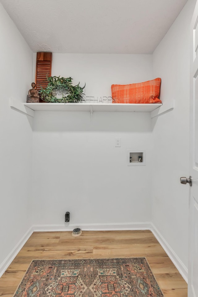 laundry room with baseboards, wood finished floors, hookup for a washing machine, and laundry area