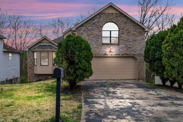 view of front facade with a lawn, a garage, aphalt driveway, and brick siding