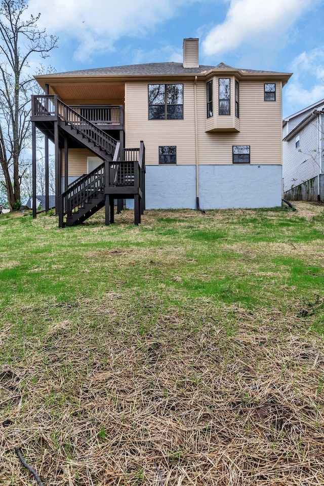 rear view of property with a yard, stairway, a wooden deck, and a chimney