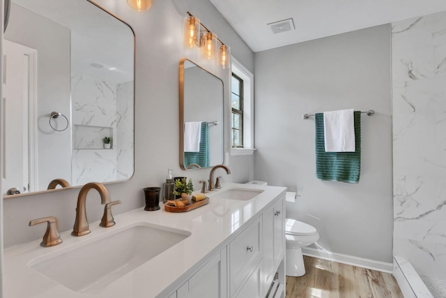 full bath with toilet, double vanity, a sink, and visible vents