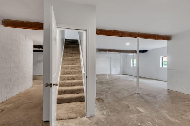 below grade area featuring stairs and concrete block wall
