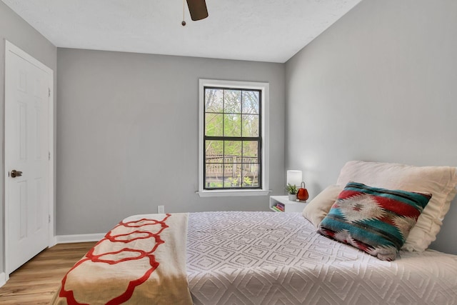 bedroom featuring wood finished floors, ceiling fan, and baseboards