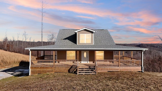 farmhouse featuring covered porch and roof with shingles