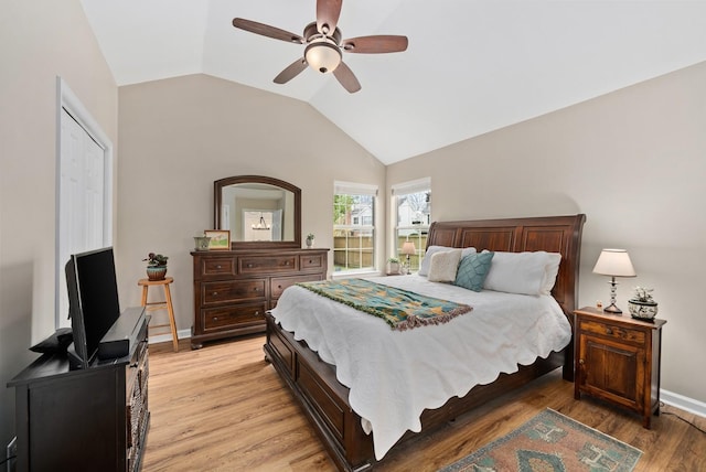 bedroom with vaulted ceiling, a ceiling fan, baseboards, and light wood-type flooring