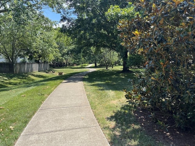 view of community featuring a yard and fence